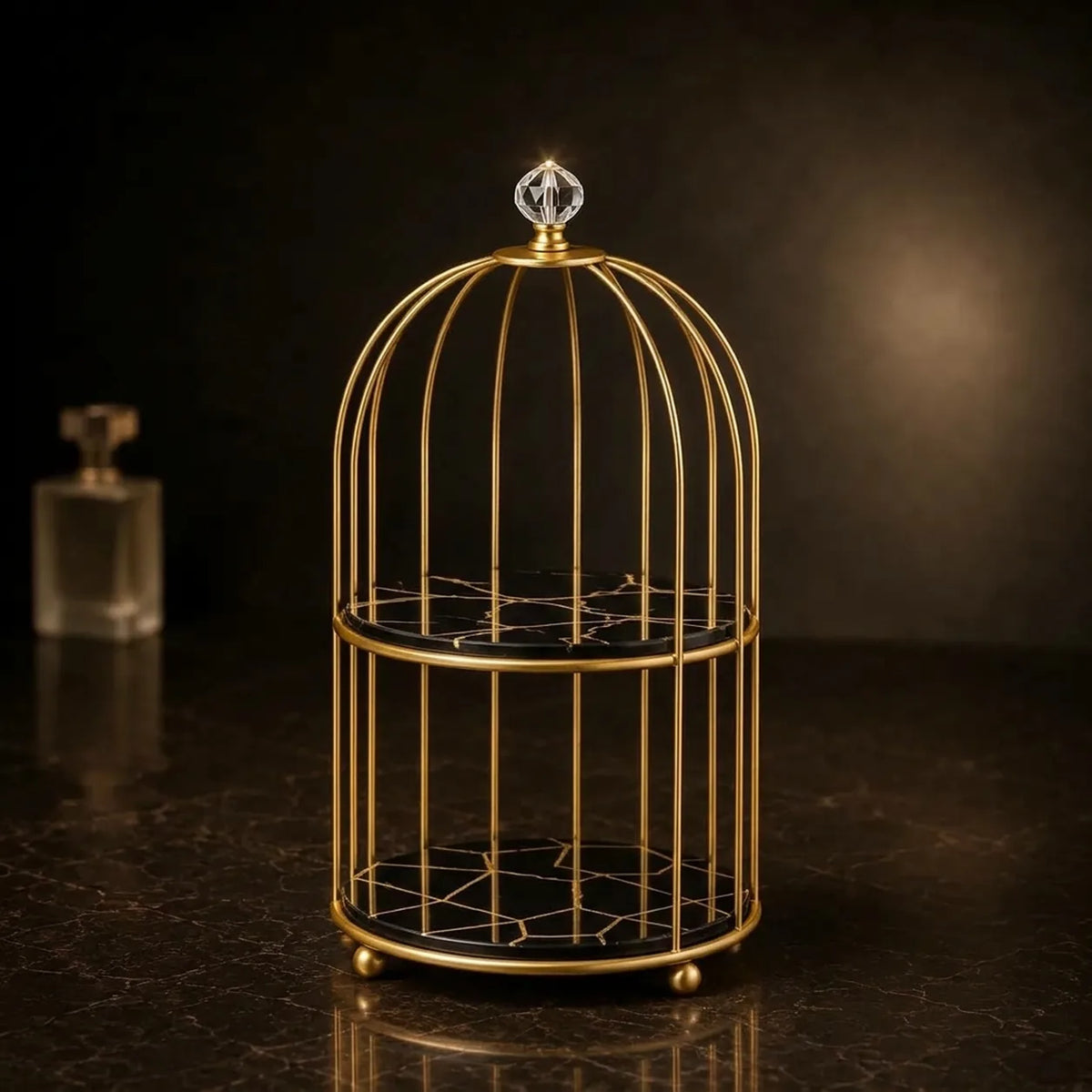 Vanity cage organizer in Onyx — black plates with a gold facet pattern, gold cage frame and crystal finial