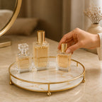 Hands setting a perfume bottle onto the gold-rim tray