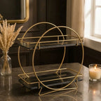 Round two-tier vanity organizer in Onyx — black marble shelves passing through a gold ring frame on splayed gold feet