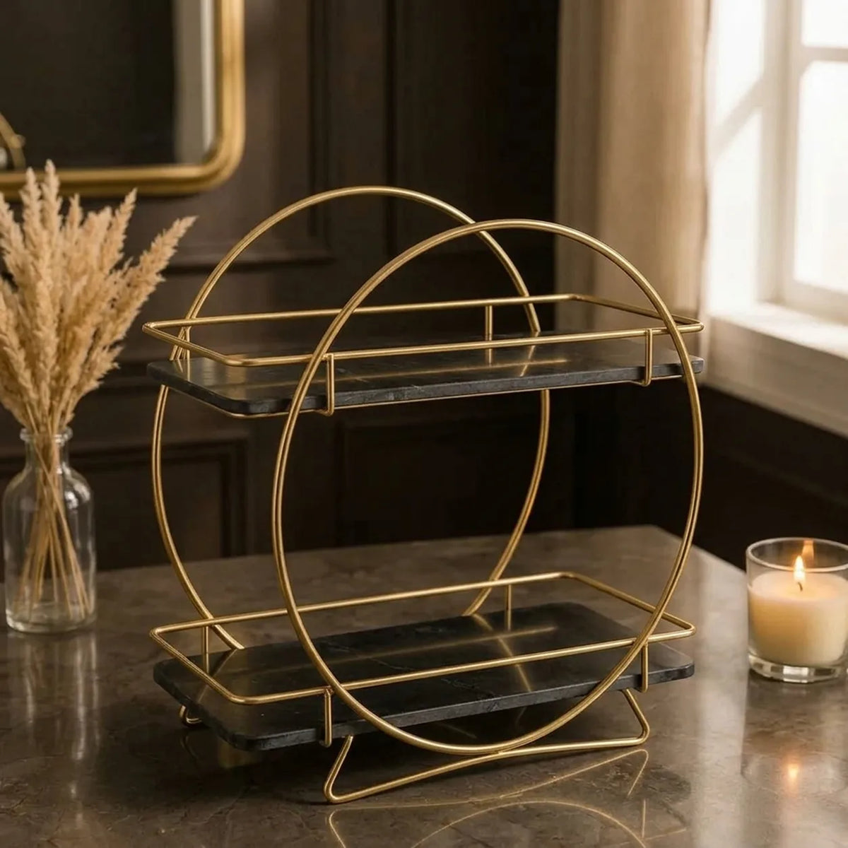 Round two-tier vanity organizer in Onyx — black marble shelves passing through a gold ring frame on splayed gold feet