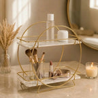 Round two-tier organizer in Pearl holding brushes, lipstick and a compact on a marble counter